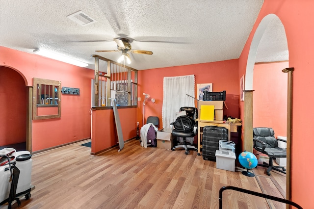 office featuring light hardwood / wood-style floors, a textured ceiling, and ceiling fan