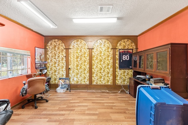 office with a textured ceiling, ornamental molding, and light wood-type flooring