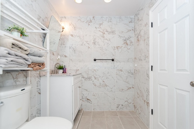 bathroom with vanity, tile walls, and toilet