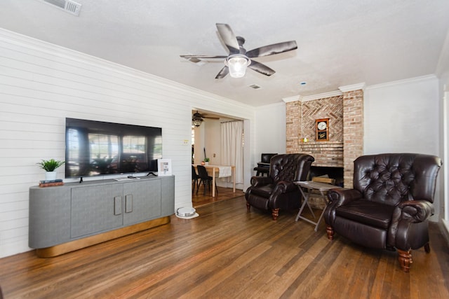 living room with ceiling fan, dark hardwood / wood-style flooring, ornamental molding, and wooden walls