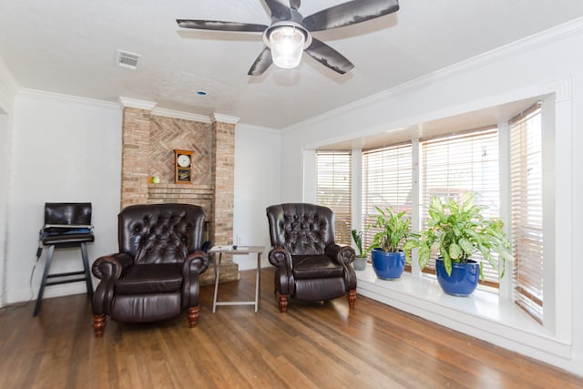 sitting room with wood-type flooring, ceiling fan, and ornamental molding