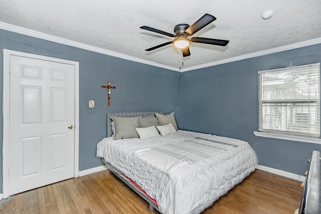 bedroom featuring ceiling fan, crown molding, a textured ceiling, and hardwood / wood-style flooring