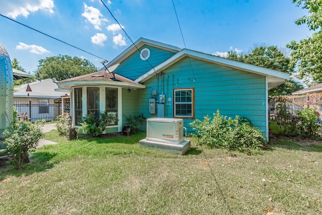 back of property featuring a sunroom and a yard