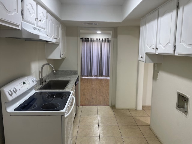 kitchen with electric stove, light tile patterned flooring, sink, and white cabinets