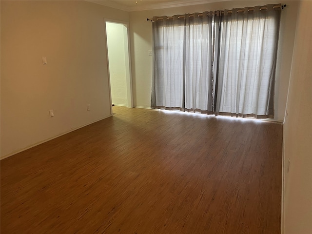 empty room featuring hardwood / wood-style floors and crown molding