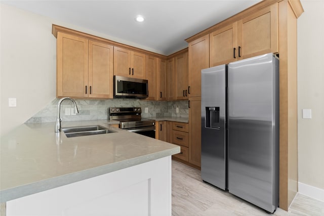 kitchen featuring light hardwood / wood-style flooring, kitchen peninsula, stainless steel appliances, backsplash, and sink