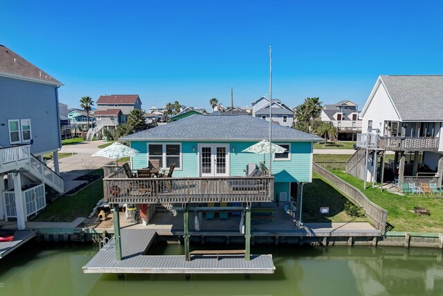 22819 Vida St, Galveston, TX 77554 - back of property with a deck with water view, a residential view, stairs, a fenced backyard, and roof with shingles