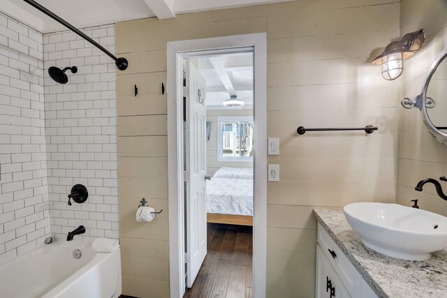 22819 Vida St, Galveston, TX 77554 - full bathroom featuring tub / shower combination, connected bathroom, wood finished floors, tile walls, and vanity
