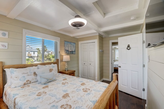 22819 Vida St, Galveston, TX 77554 - bedroom with multiple windows, dark wood finished floors, wood walls, beam ceiling, and a closet