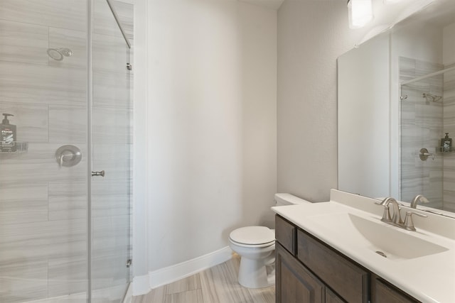 bathroom with toilet, an enclosed shower, and vanity