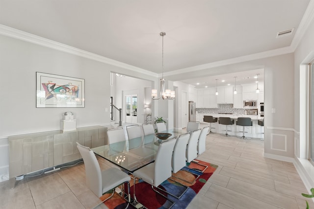 dining space featuring crown molding and a notable chandelier