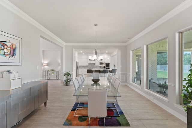 tiled dining space with crown molding and a notable chandelier