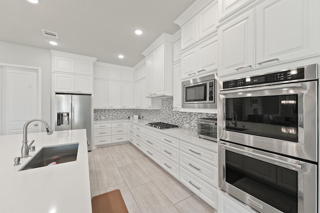 kitchen featuring white cabinets, tasteful backsplash, sink, and stainless steel appliances