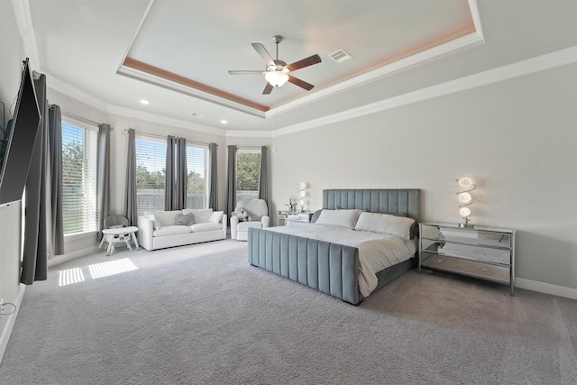 carpeted bedroom with crown molding, ceiling fan, and a raised ceiling