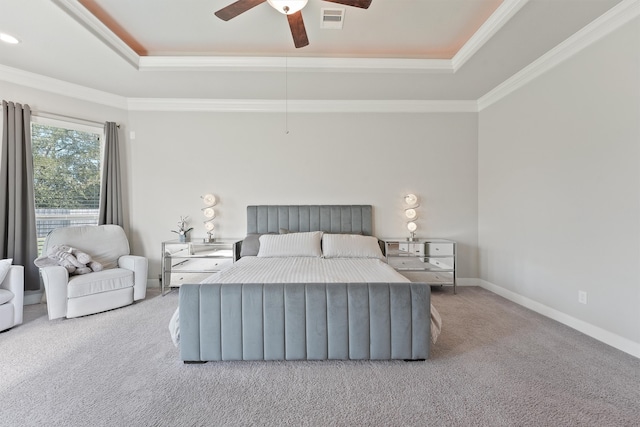 bedroom featuring crown molding, light colored carpet, a tray ceiling, and ceiling fan