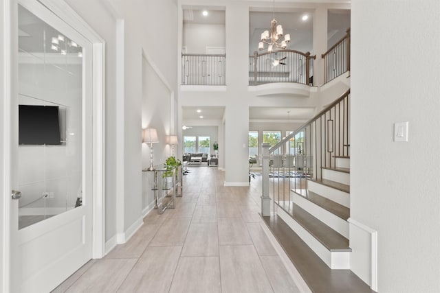 foyer with an inviting chandelier and a towering ceiling