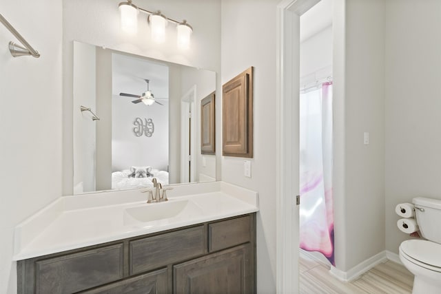 bathroom with vanity, toilet, curtained shower, and ceiling fan