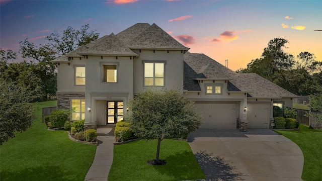 french country style house with a garage and a lawn