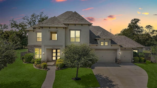 french provincial home with a yard and a garage