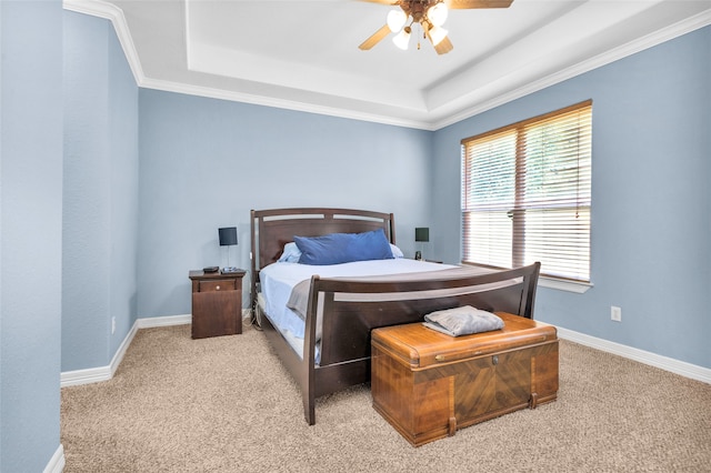 bedroom featuring a tray ceiling, ceiling fan, carpet flooring, and ornamental molding