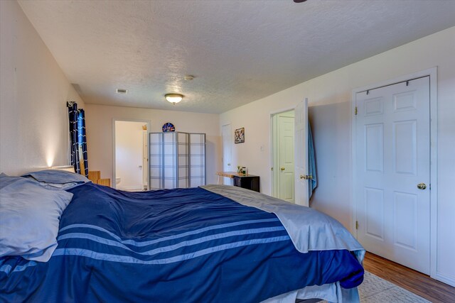 bedroom featuring a textured ceiling and hardwood / wood-style floors