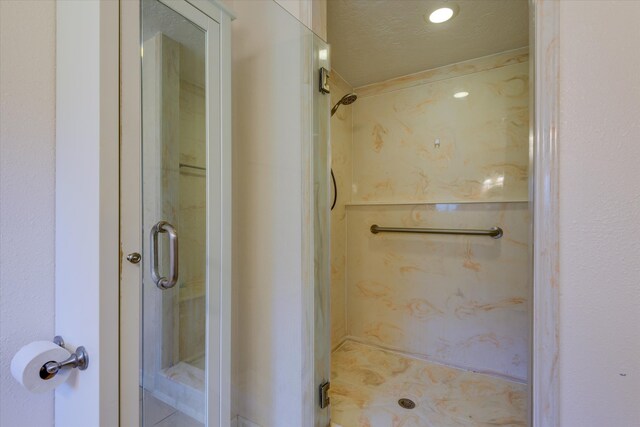 bathroom featuring a textured ceiling and an enclosed shower