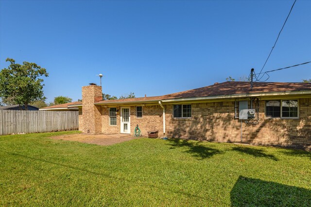 back of property with a yard and a patio