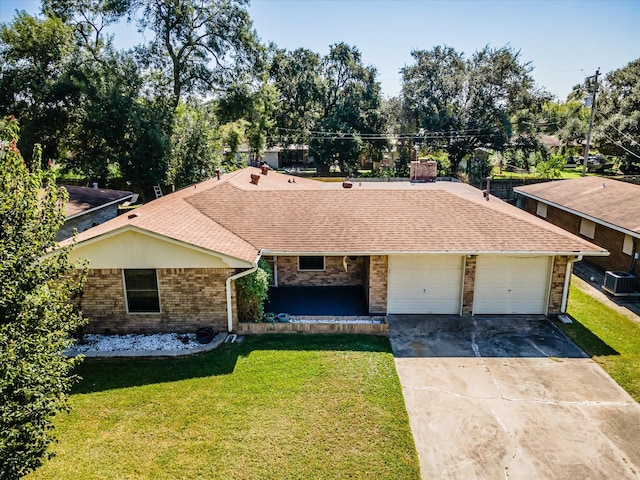 ranch-style house with a garage, a front lawn, and central AC unit