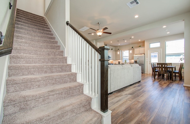 stairs with ceiling fan and wood-type flooring