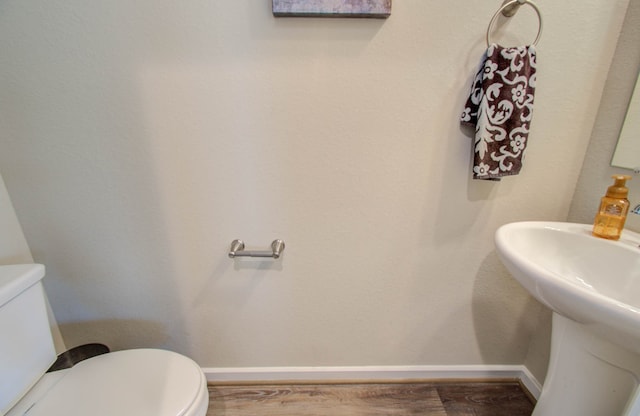 bathroom featuring wood-type flooring and toilet