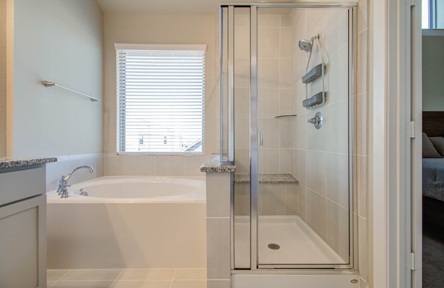 bathroom featuring vanity, independent shower and bath, and tile patterned flooring