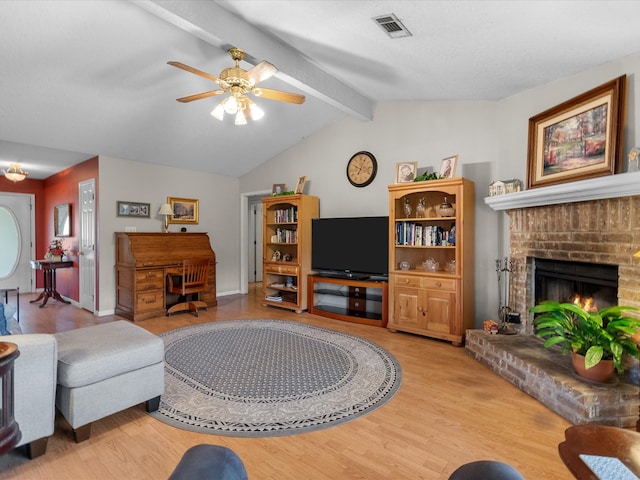 living room featuring light hardwood / wood-style floors, lofted ceiling with beams, a brick fireplace, and ceiling fan