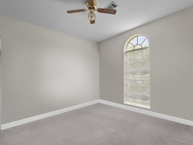 empty room featuring a textured ceiling, ceiling fan, and carpet floors