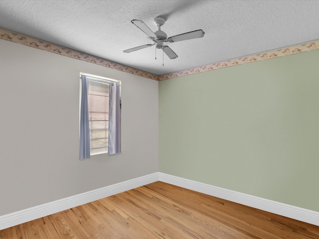 empty room with ceiling fan, hardwood / wood-style flooring, and a textured ceiling