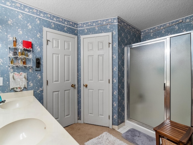 bathroom featuring vanity, a textured ceiling, and an enclosed shower