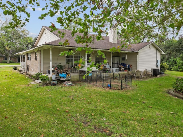 rear view of house with a yard, a patio, and central air condition unit