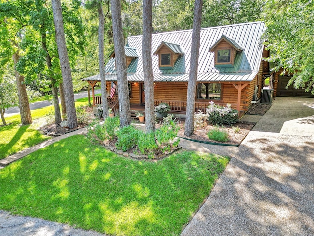 log home featuring central air condition unit, a front yard, a porch, and a garage