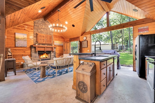 kitchen featuring an outdoor stone fireplace, beamed ceiling, wooden walls, hanging light fixtures, and sink