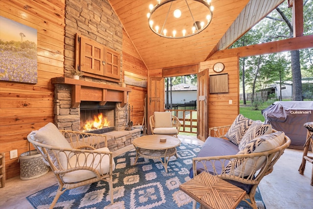 living room with an outdoor stone fireplace, wooden ceiling, wooden walls, and high vaulted ceiling