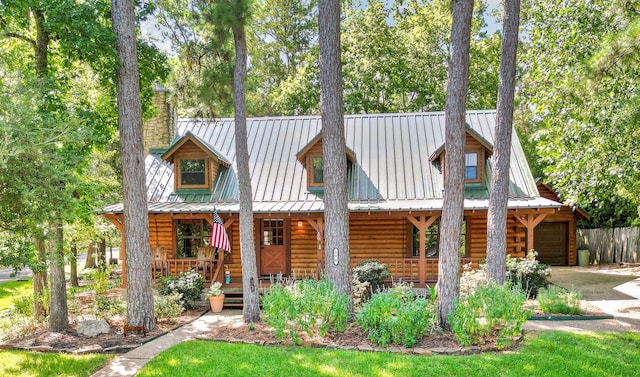 log home with covered porch and a garage