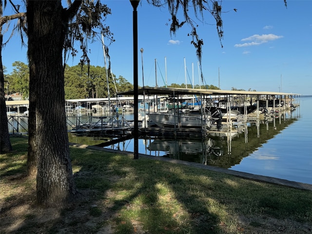 view of dock with a water view and a yard