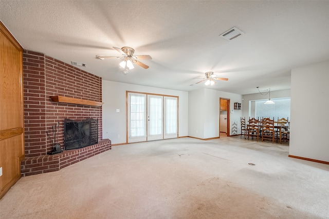 unfurnished living room featuring a fireplace, a textured ceiling, carpet, and ceiling fan