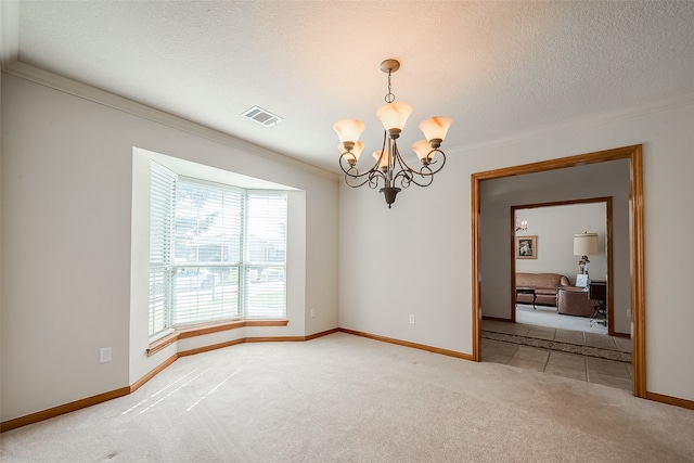 carpeted empty room with ornamental molding, a textured ceiling, and a chandelier