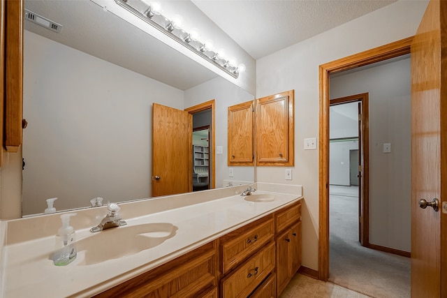 bathroom with vanity, tile patterned floors, and a textured ceiling