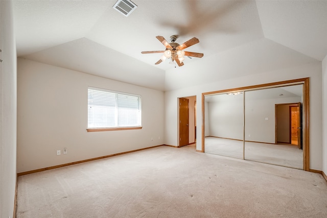 unfurnished bedroom featuring a closet, ceiling fan, lofted ceiling, and light colored carpet