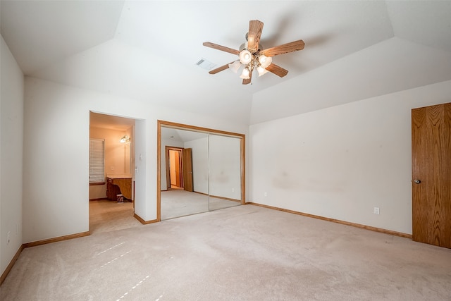 unfurnished bedroom with lofted ceiling, ceiling fan, ensuite bathroom, a closet, and light colored carpet