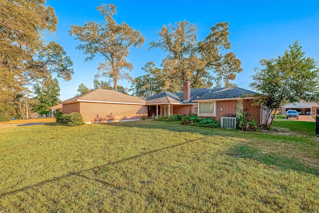 view of front of property featuring a front lawn and central AC unit