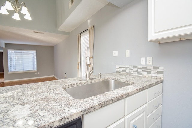 kitchen featuring backsplash, sink, white cabinets, and a healthy amount of sunlight