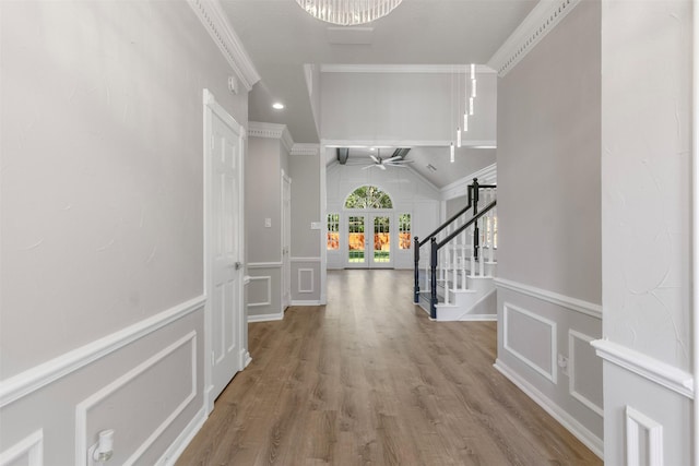 foyer entrance with ceiling fan, ornamental molding, lofted ceiling, and hardwood / wood-style flooring