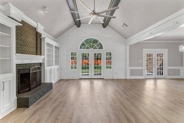 unfurnished living room with a fireplace, french doors, and light wood-type flooring